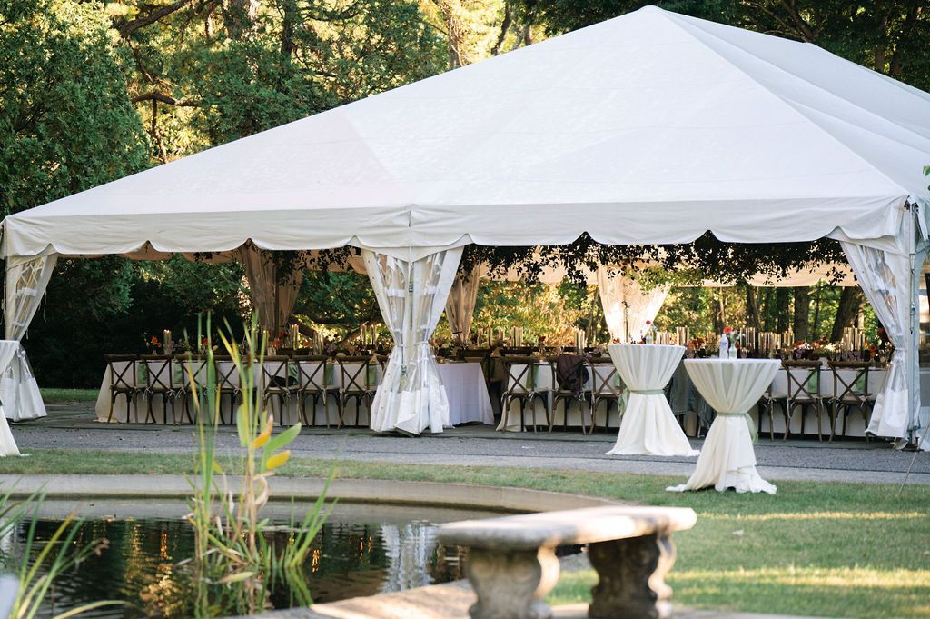 White wedding tents set up on a manicured lawn for an outdoor celebration.