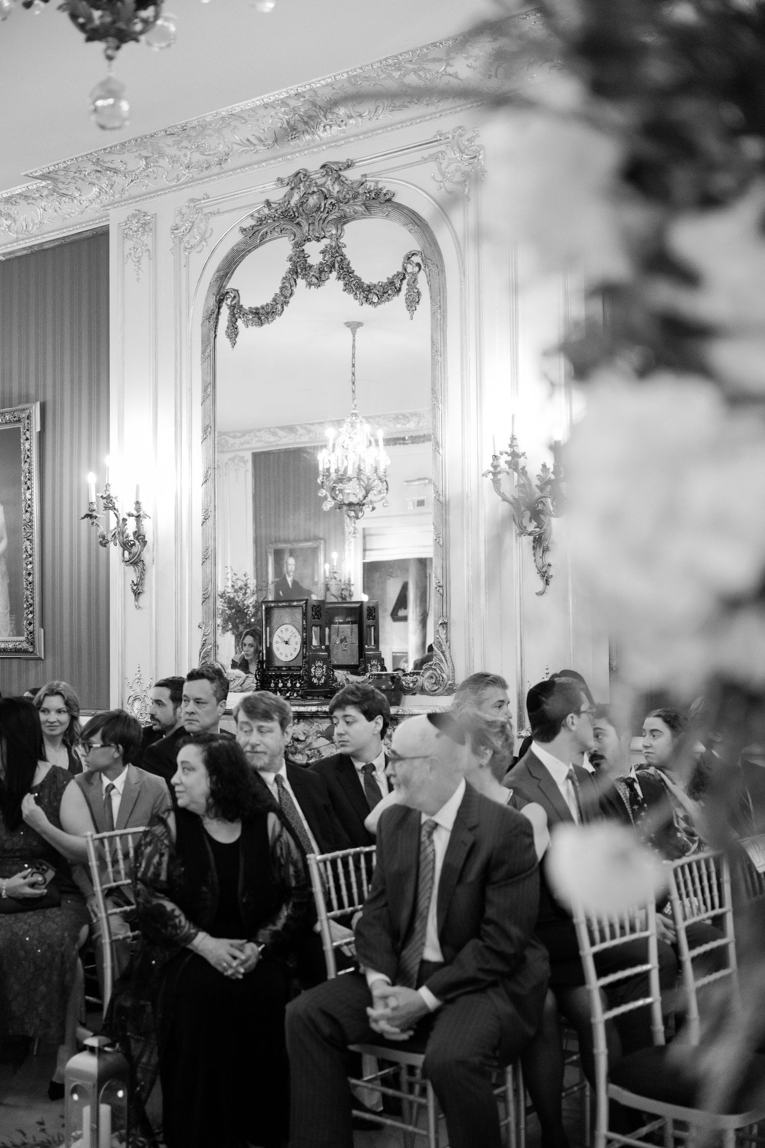 Black and white photo of wedding guests seated in an ornate ballroom with crystal chandeliers at a Baltimore engineers club wedding
