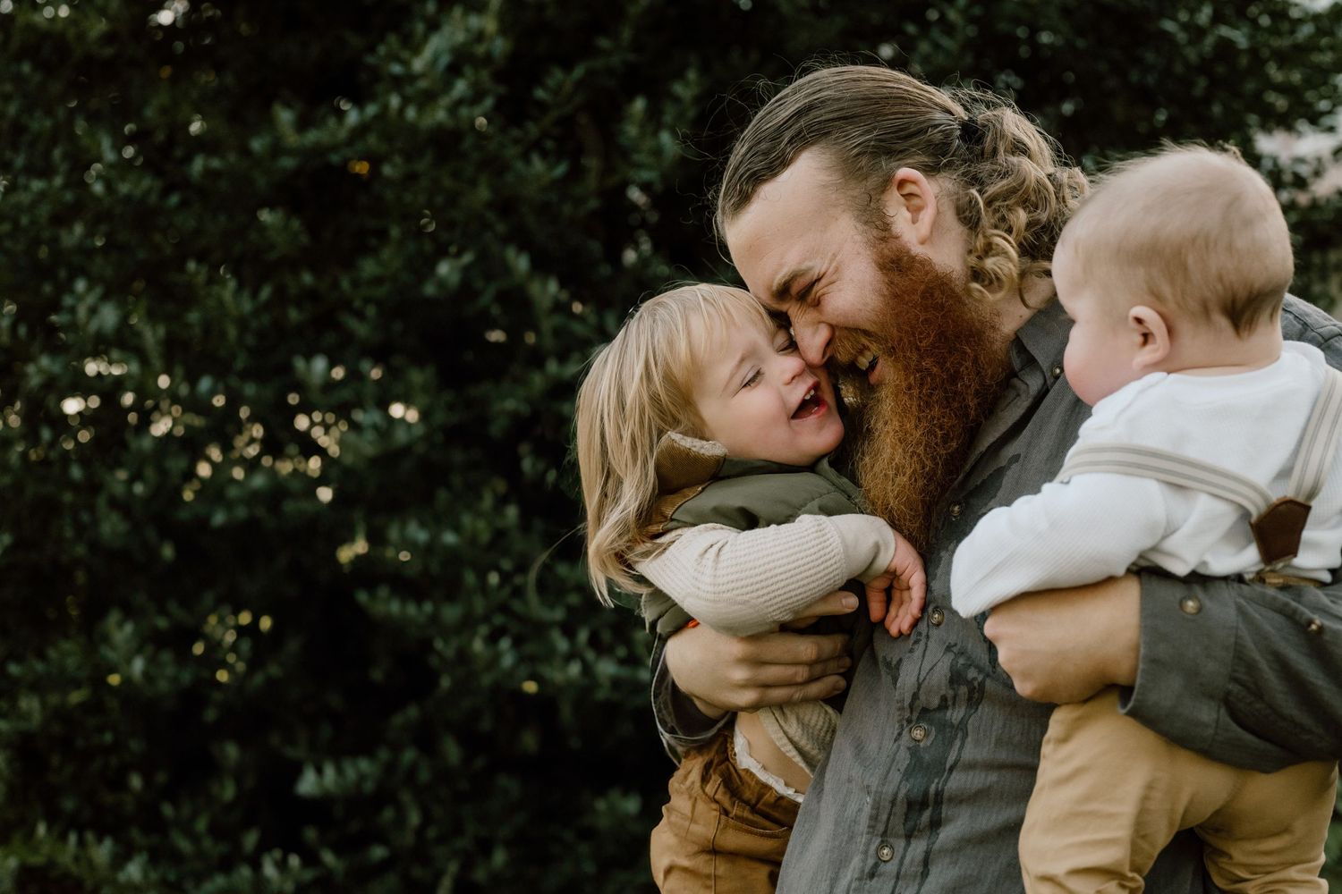 A tender family moment captured outdoors during golden hour.