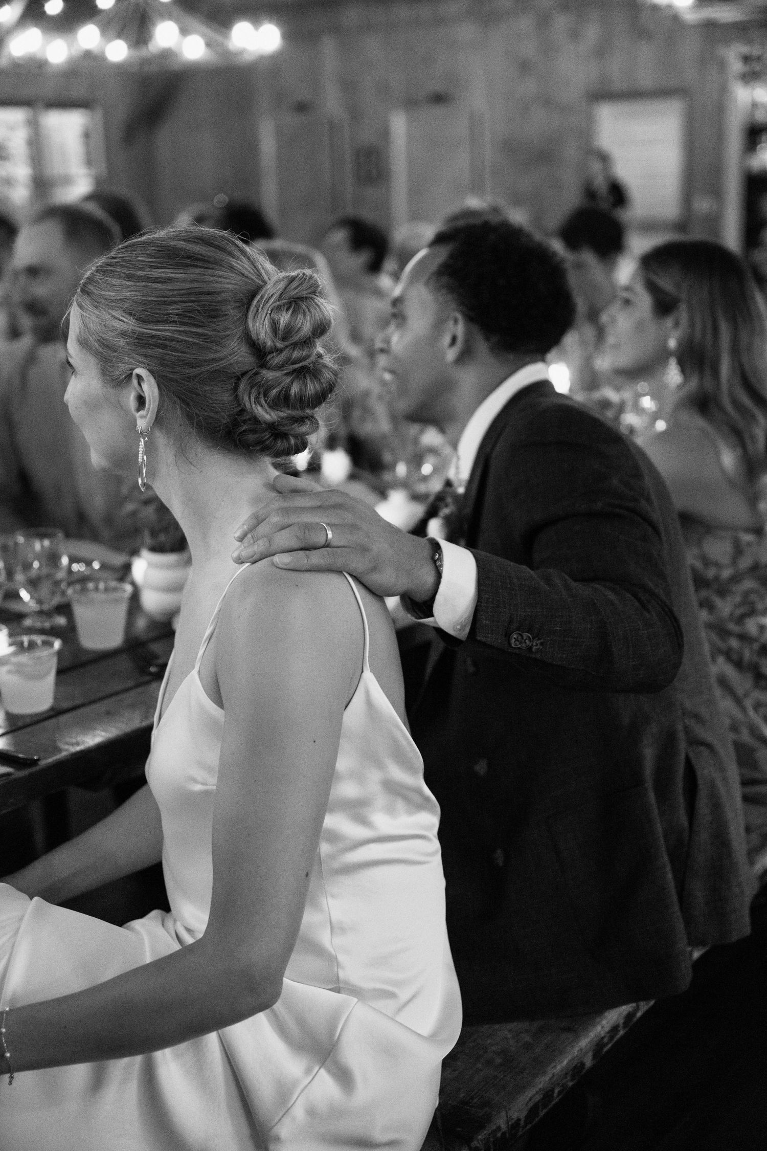 Intimate moment during wedding reception under ambient lighting.