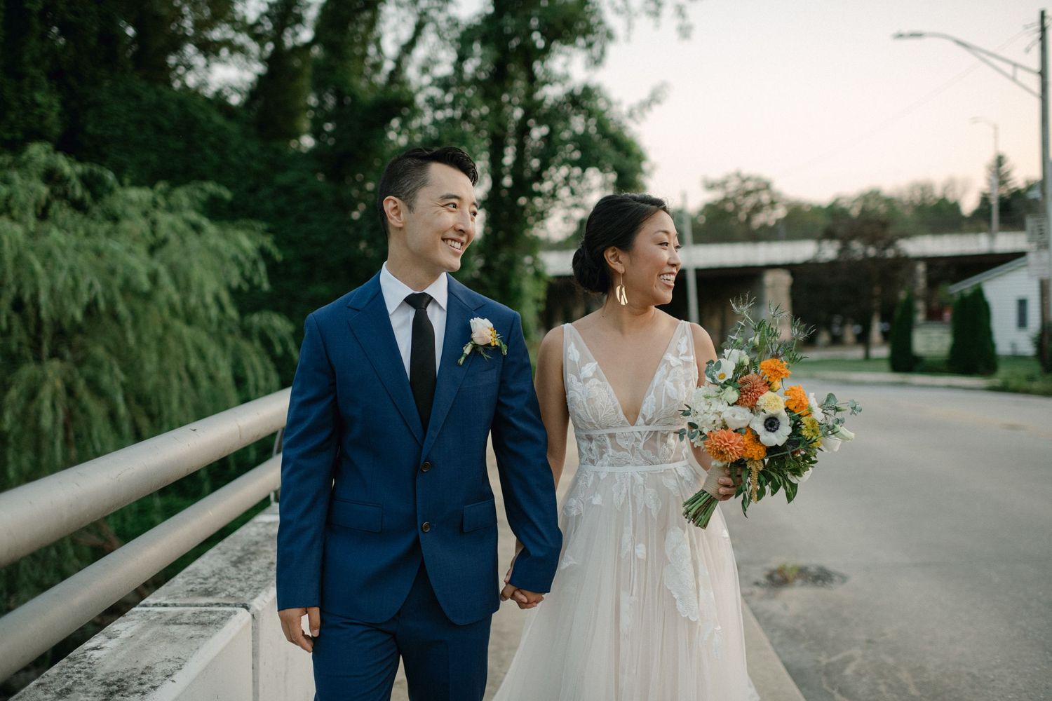 bride and groom walk together over bride in baltimore