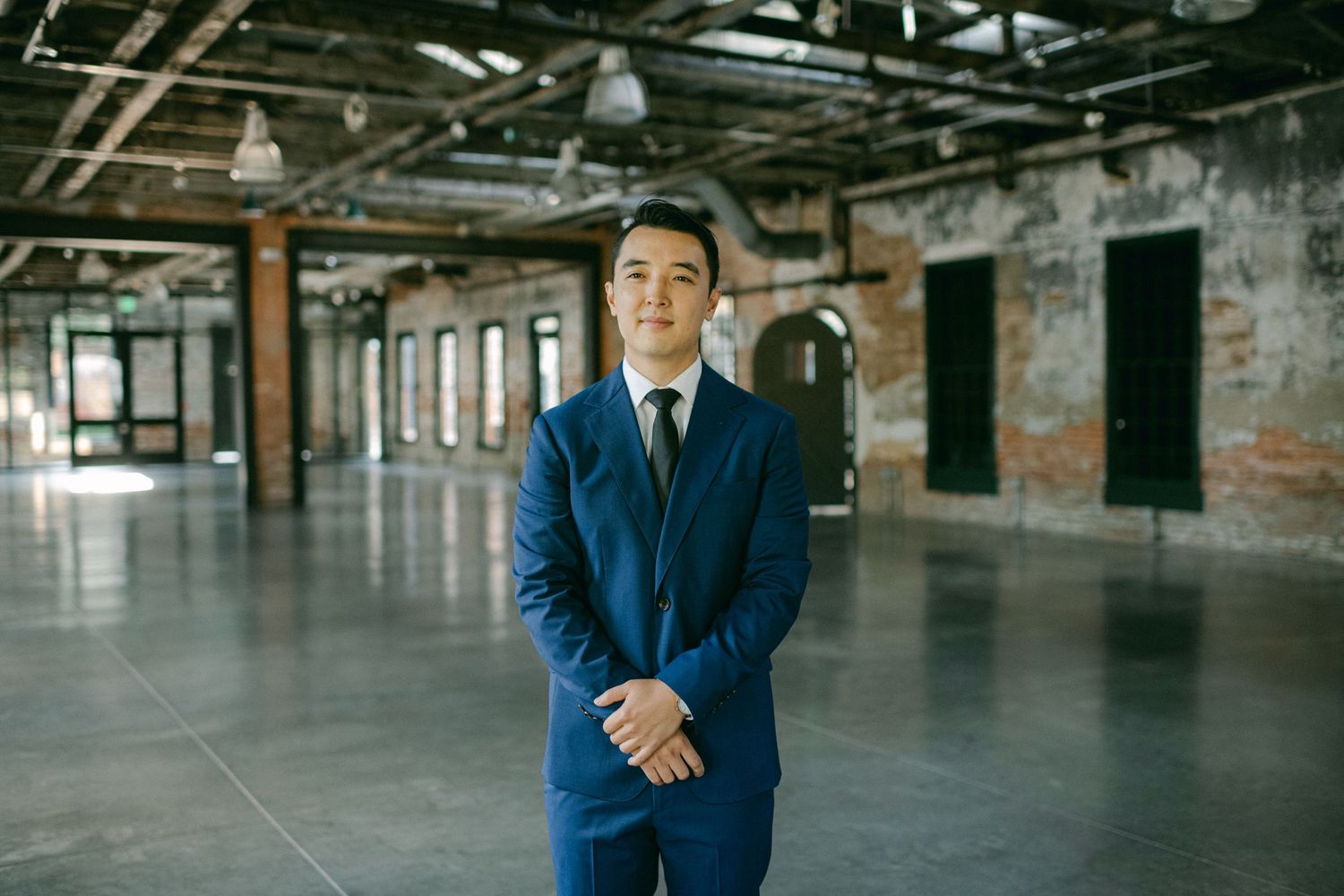 groom waits for bride in large industrial room