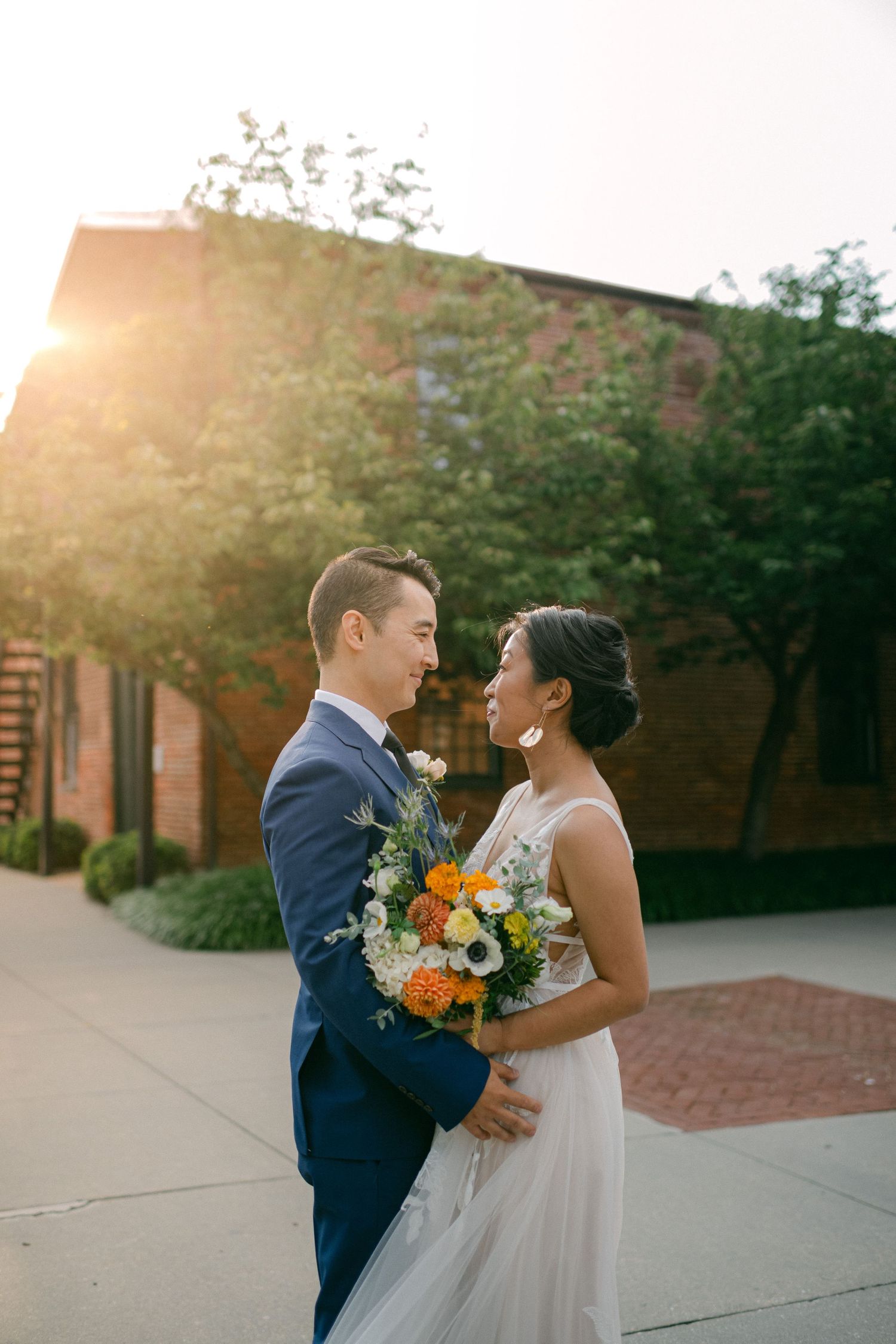 beautiful sun flare lights bride and groom as they smile on their wedding day