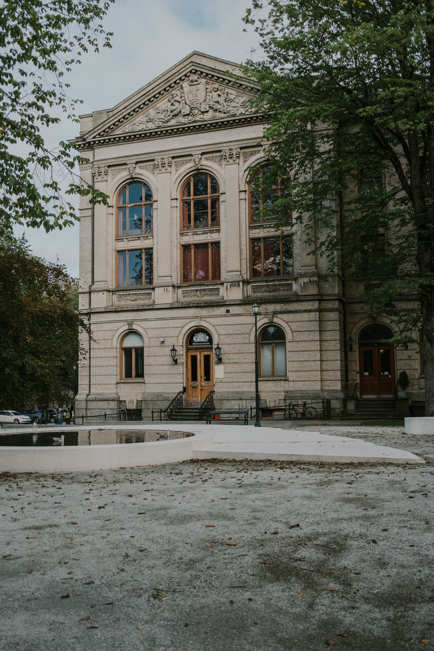 Classic neoclassical building with arched windows and ornate facade in winter setting.