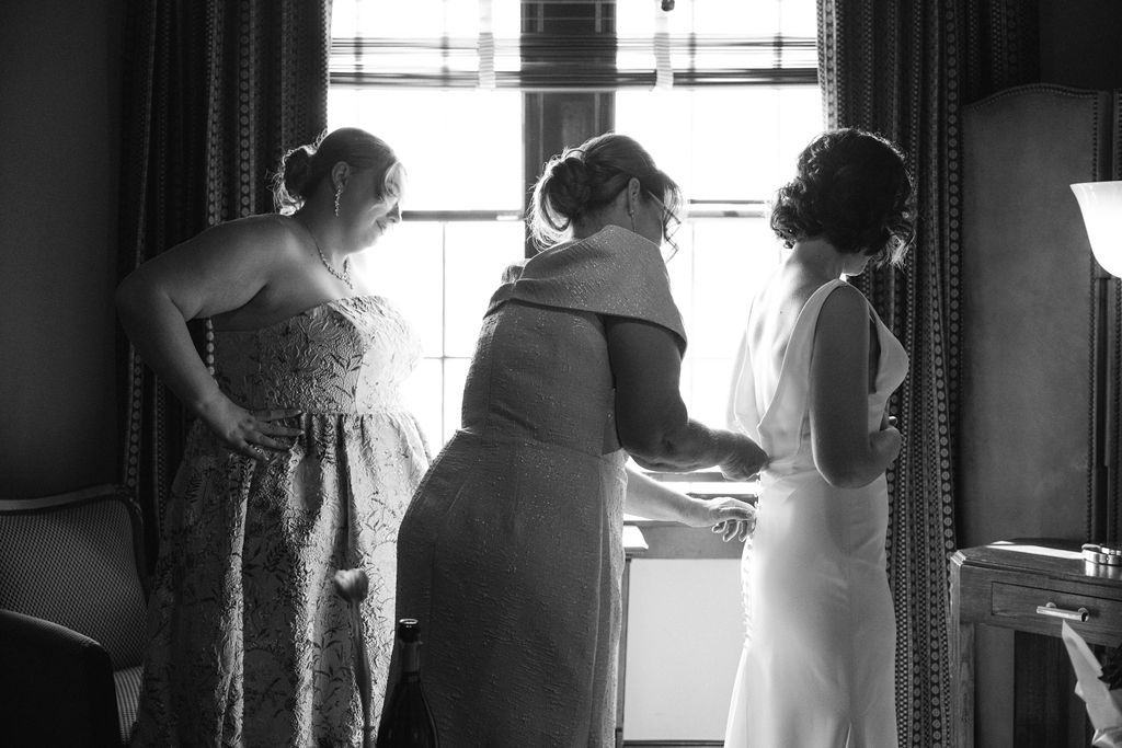 A series of silhouetted figures stand by windows in black and white photos creating a moody atmospheric effect.