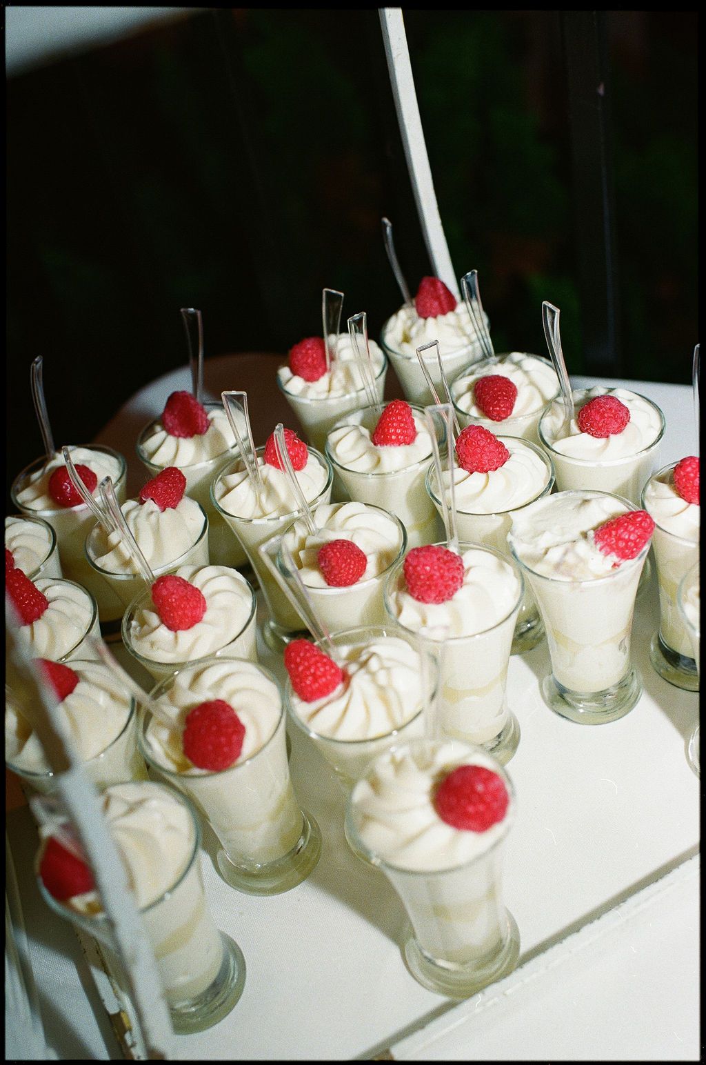 Mini dessert shooters topped with whipped cream and fresh raspberries arranged on a serving tray at Strong Mansion on Sugarloaf Mountain