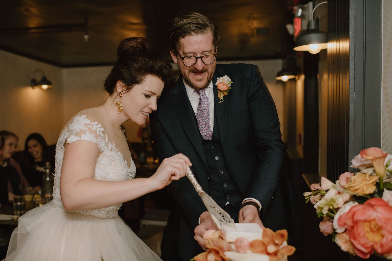 Couple examining their wedding cake together at reception.