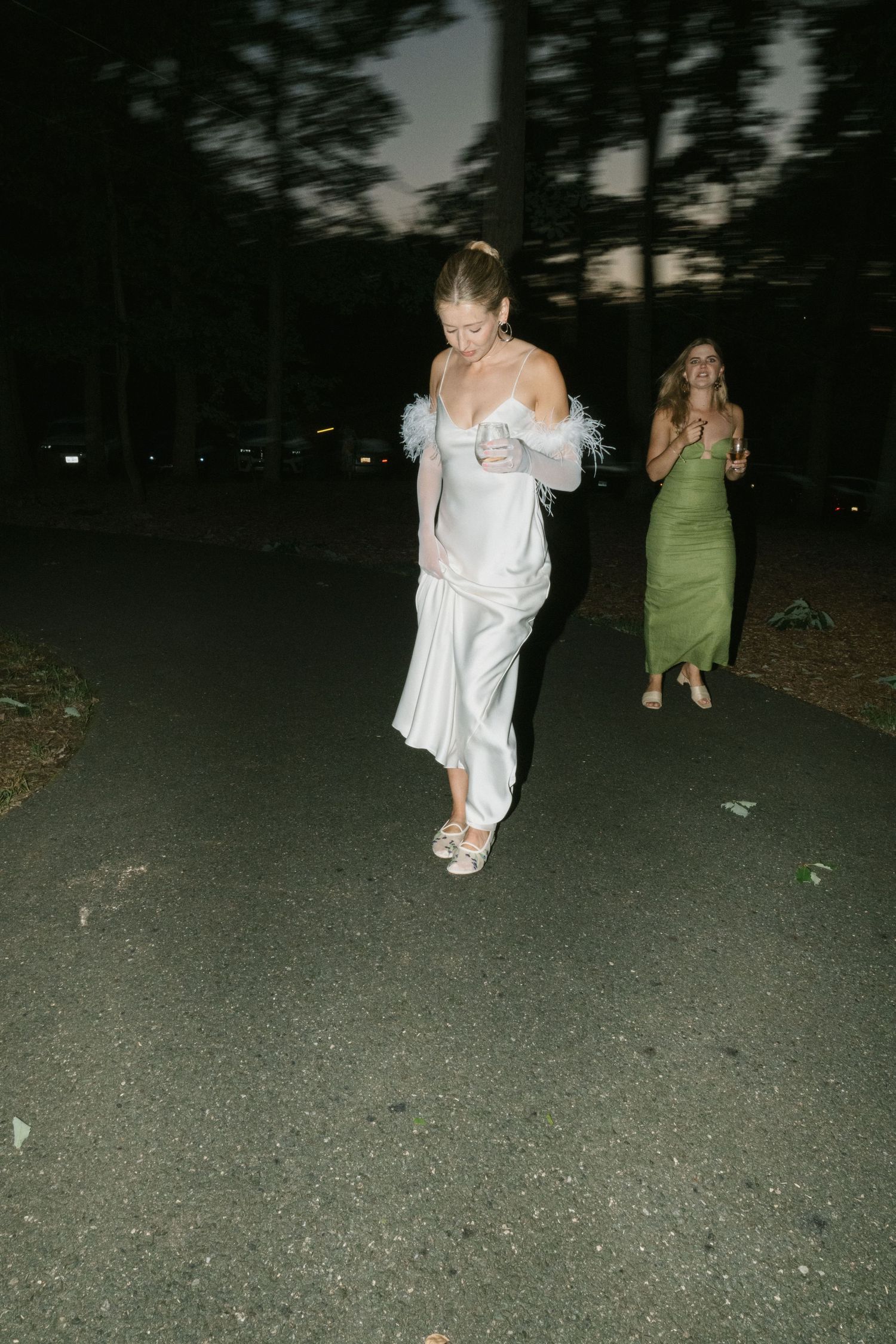 Late night wedding celebration with guests dancing on a dark outdoor path.