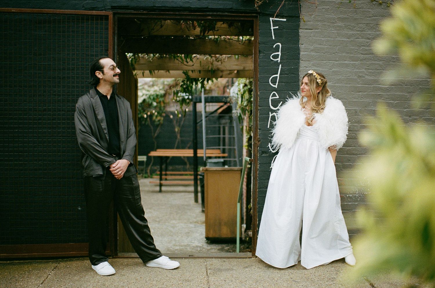A black and white wedding photoshoot showing the couple sitting and standing together in an outdoor setting at Fadensonnen in Baltimore