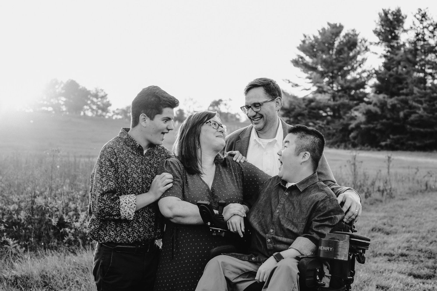 Candid black and white photo of a small group sharing a joyful moment together outdoors.