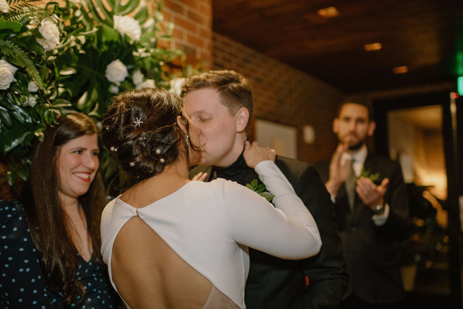 A tender embrace during a wedding reception with floral decorations.