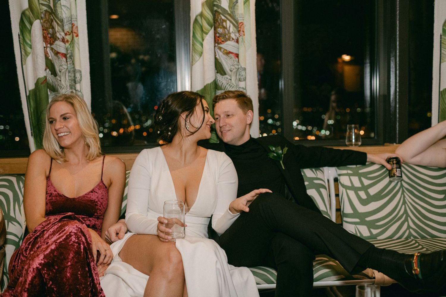 Wedding celebration guests relaxing on decorative lounge furniture.
