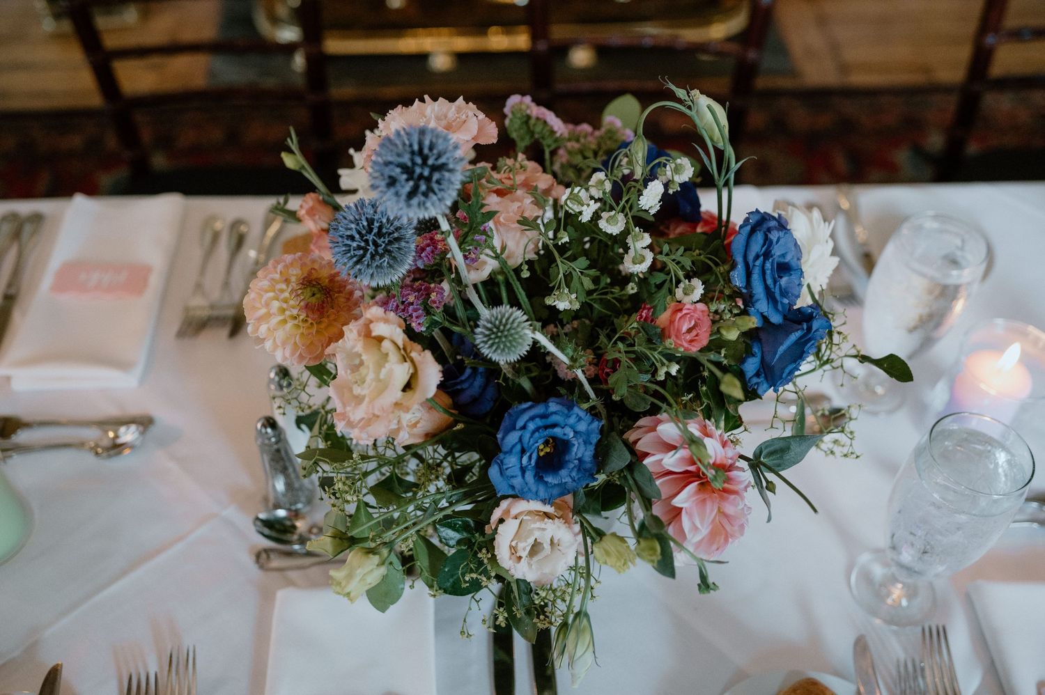 Overhead view of elegant table setting with blue and pink floral arrangement.