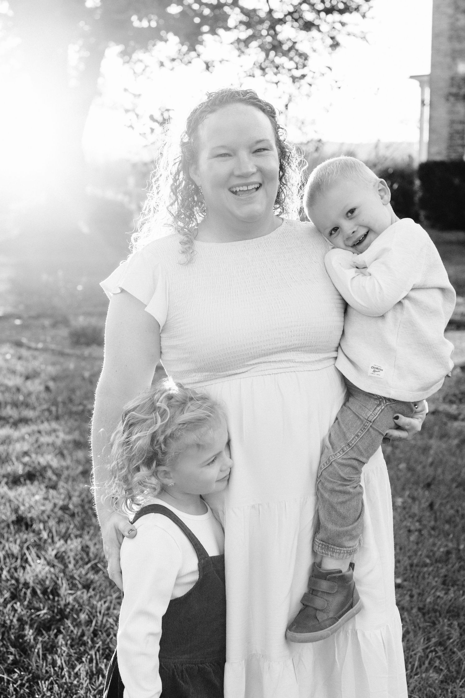 A sunlit outdoor family portrait captures joyful connections on a beautiful autumn day.