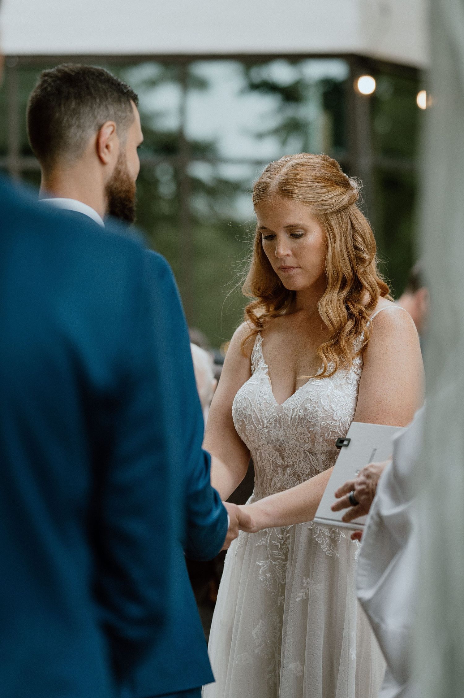 A bride and groom share a moment during their wedding ceremony outdoors.