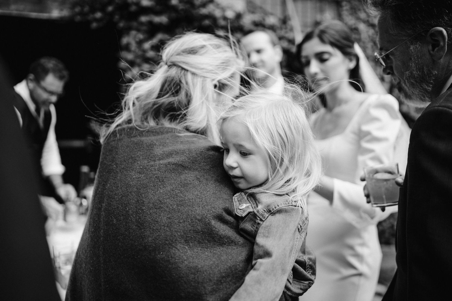 Black and white photo capturing intimate moments during a wedding reception.