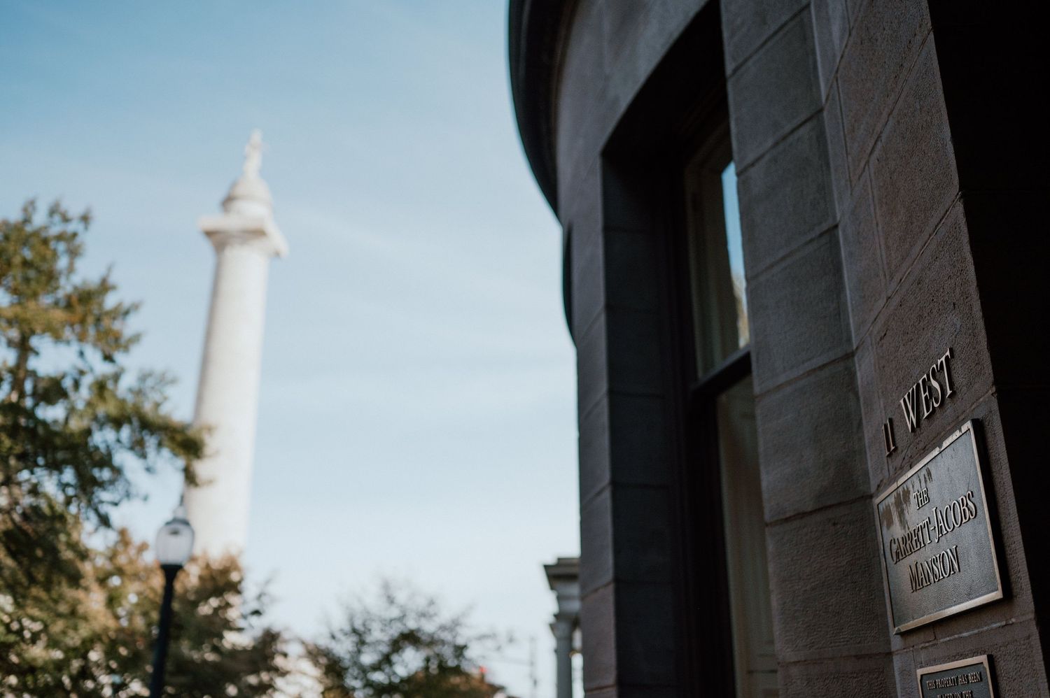 A modern architectural detail with a tall monument or tower visible against a blue sky.