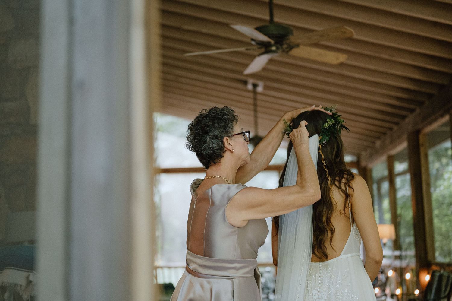 mother putting brides veil on in cabin