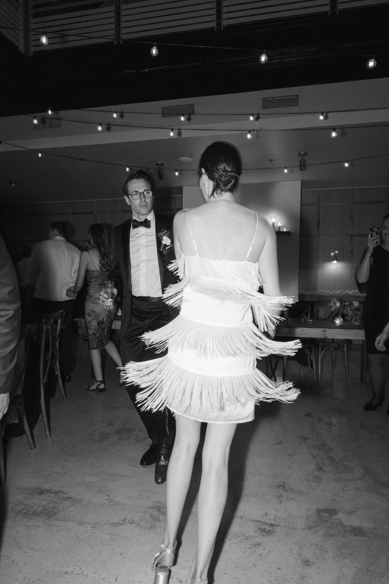 Wedding reception dance captures showing twirling dress with fringe details under venue lighting.