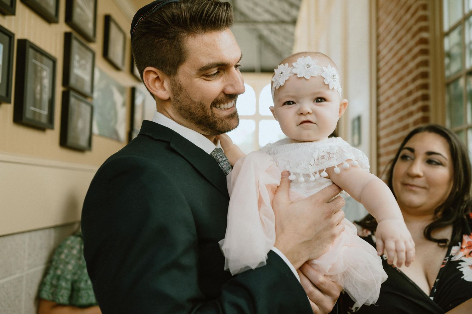 Sweet moment between parent and baby at formal celebration.