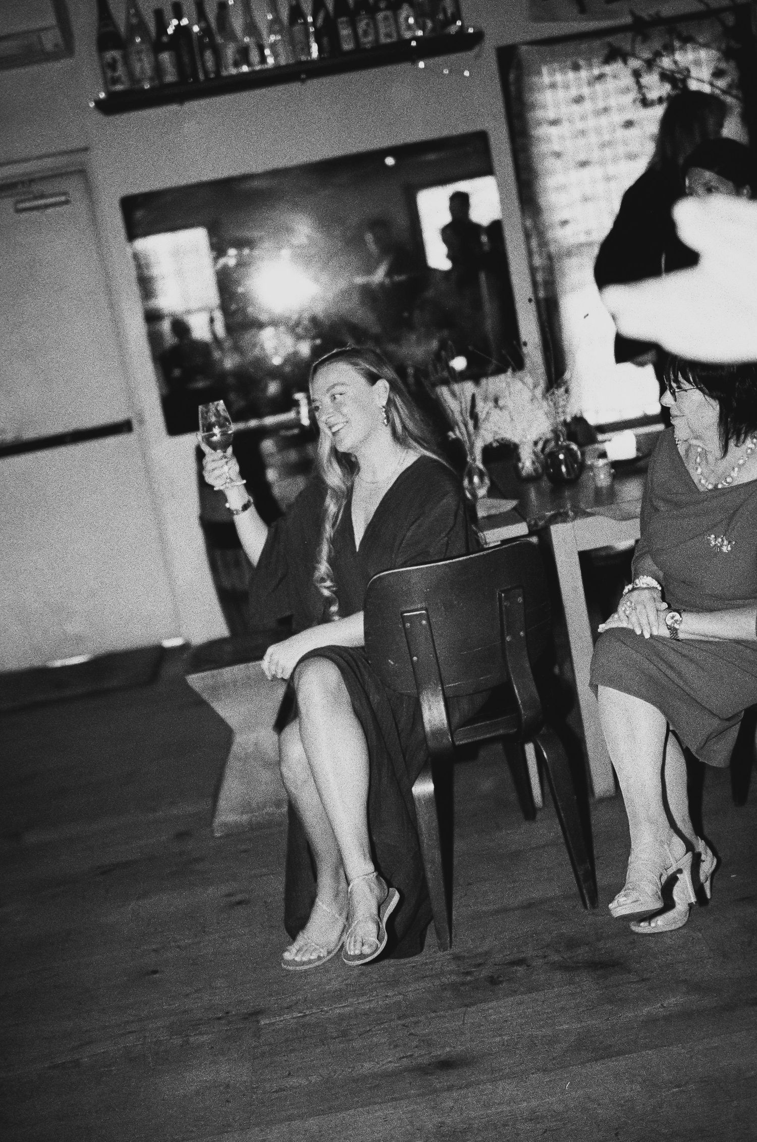 A vintage-style black and white photo of people relaxing at a bar with drinks.