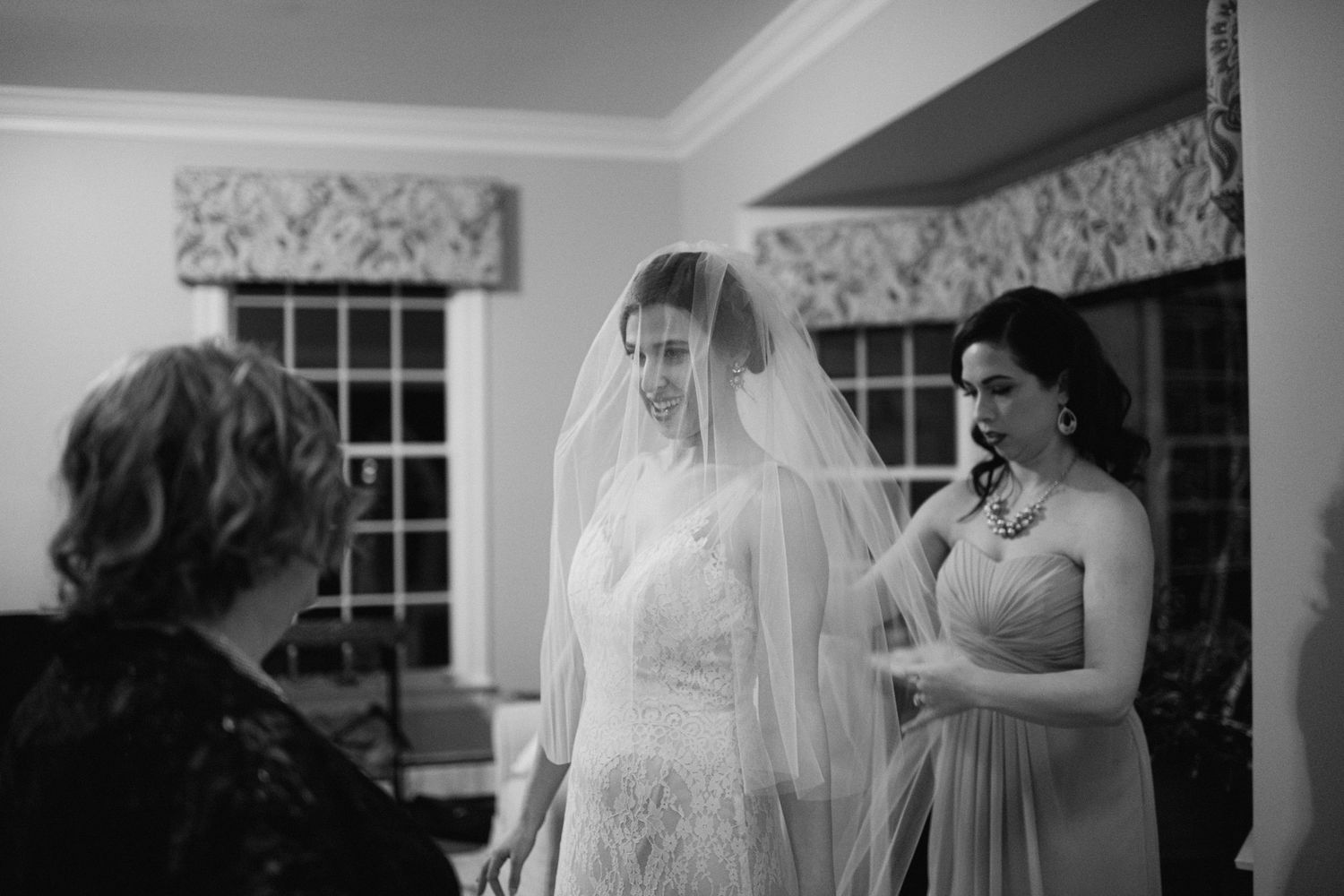 Intimate moment during wedding preparations in a room with floral window treatments.