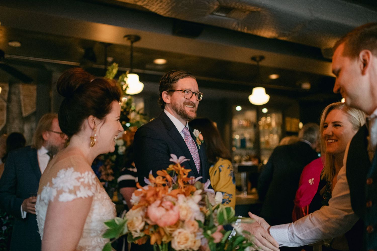 A candid wedding reception moment with laughter and joy inside a rustic venue.