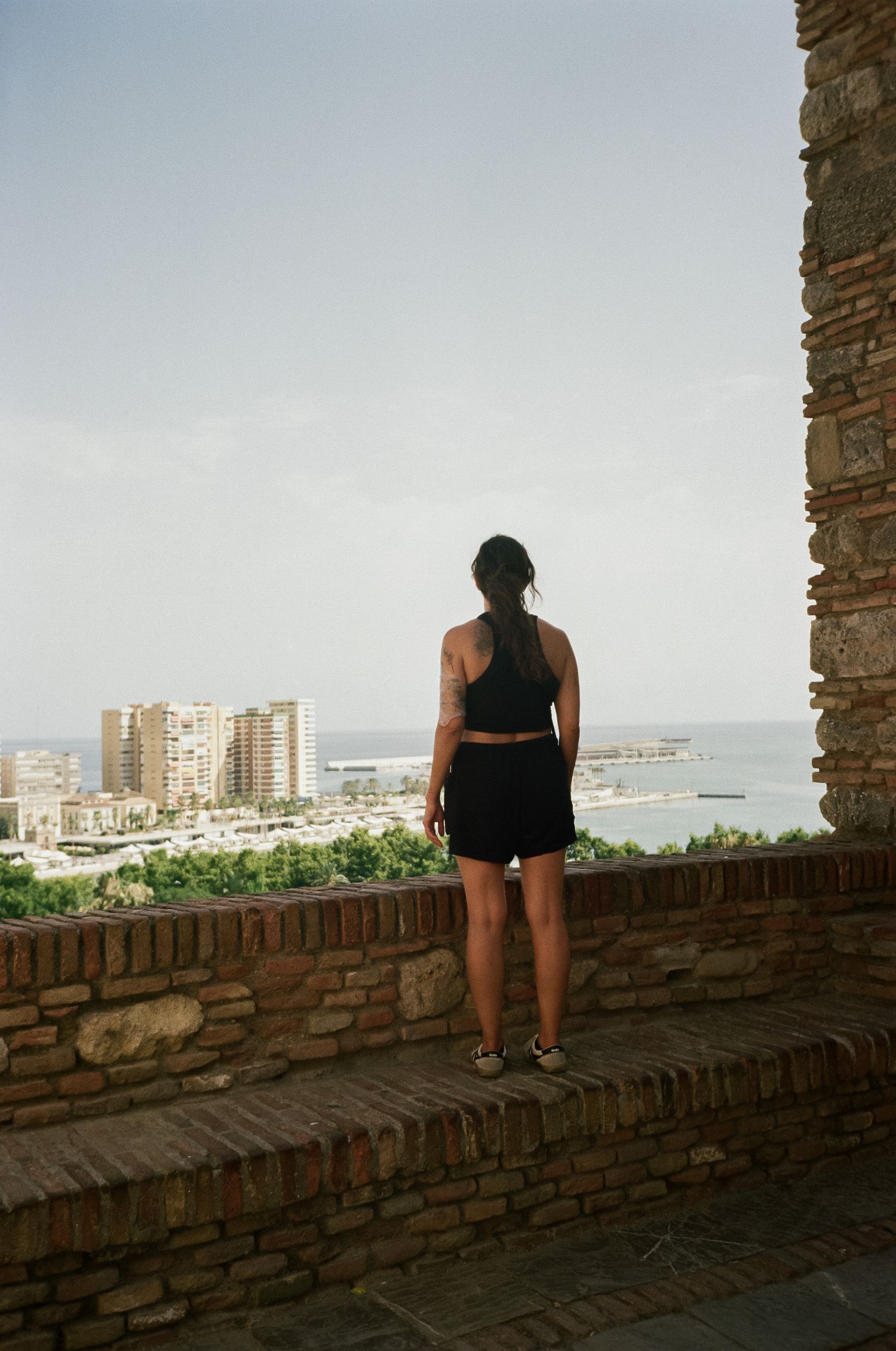 View of coastal city and harbor from ancient stone fortification wall.