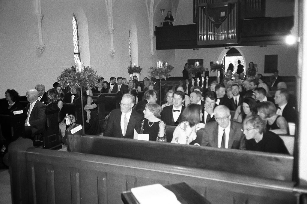 Wedding ceremony guests seated in church pews during a traditional service.