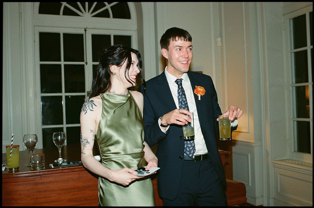 Wedding guests mingling in an elegant room with white trim and windows at Strong Mansion on Sugarloaf Mountain
