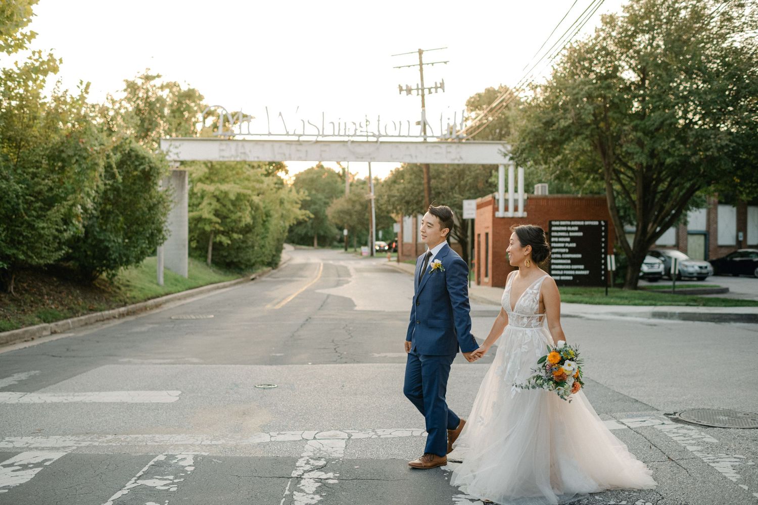 bride and groom cross street in mt washington baltimore