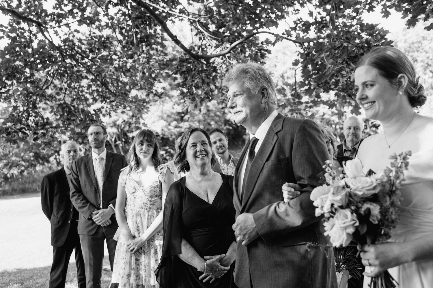Black and white photo of wedding party walking together outdoors.
