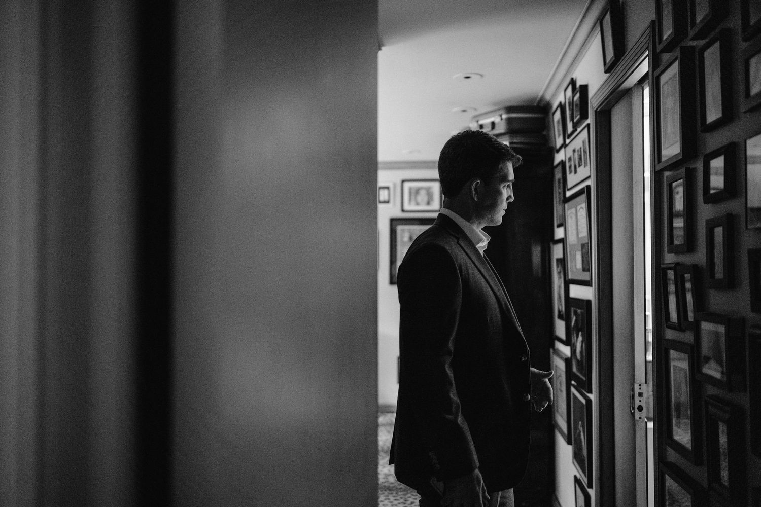 Silhouette of someone in formal attire standing in a hallway.