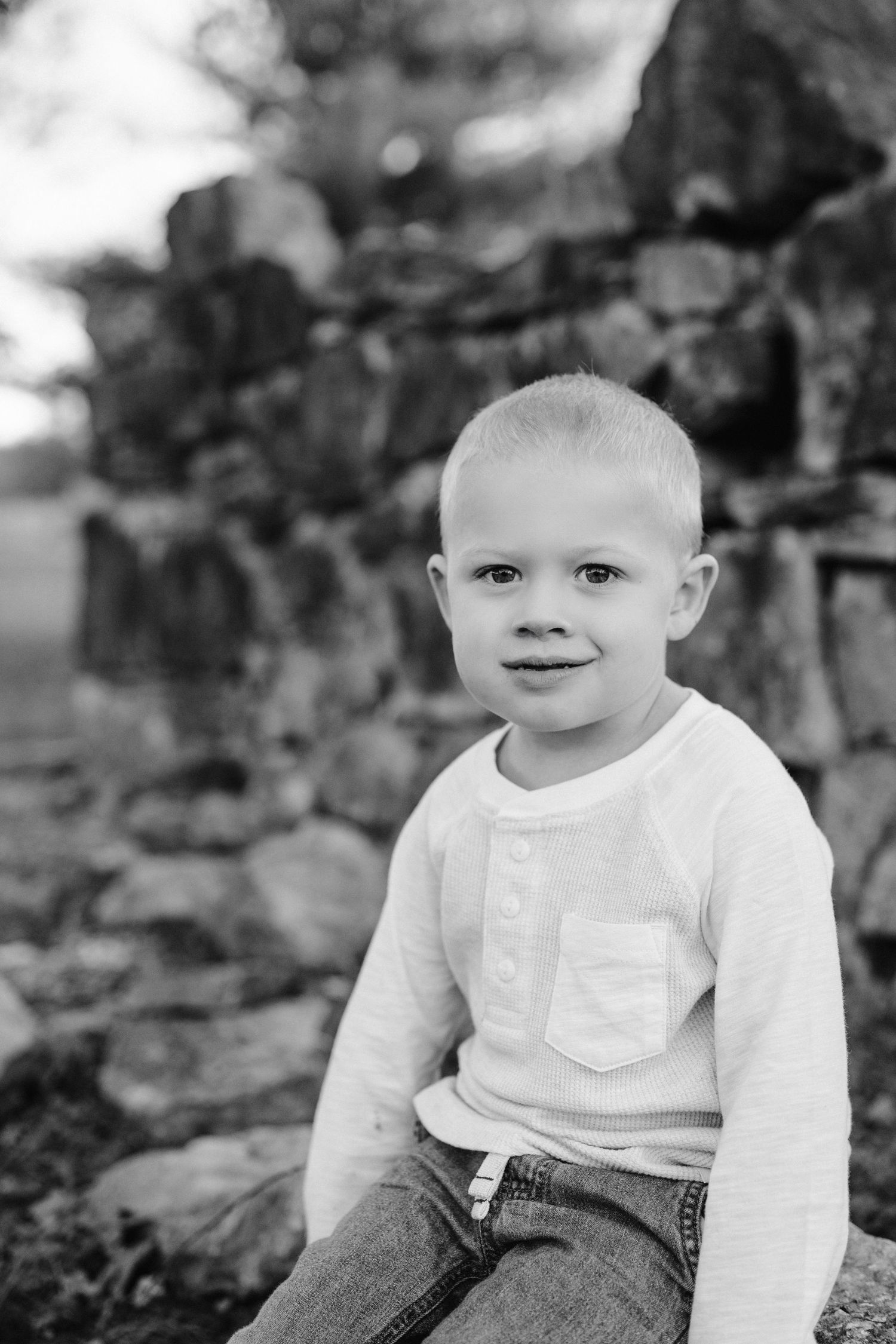 Black and white portrait against stone wall background.