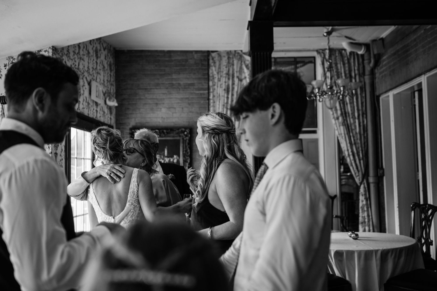 Black and white candid photo of wedding preparation moments indoors.