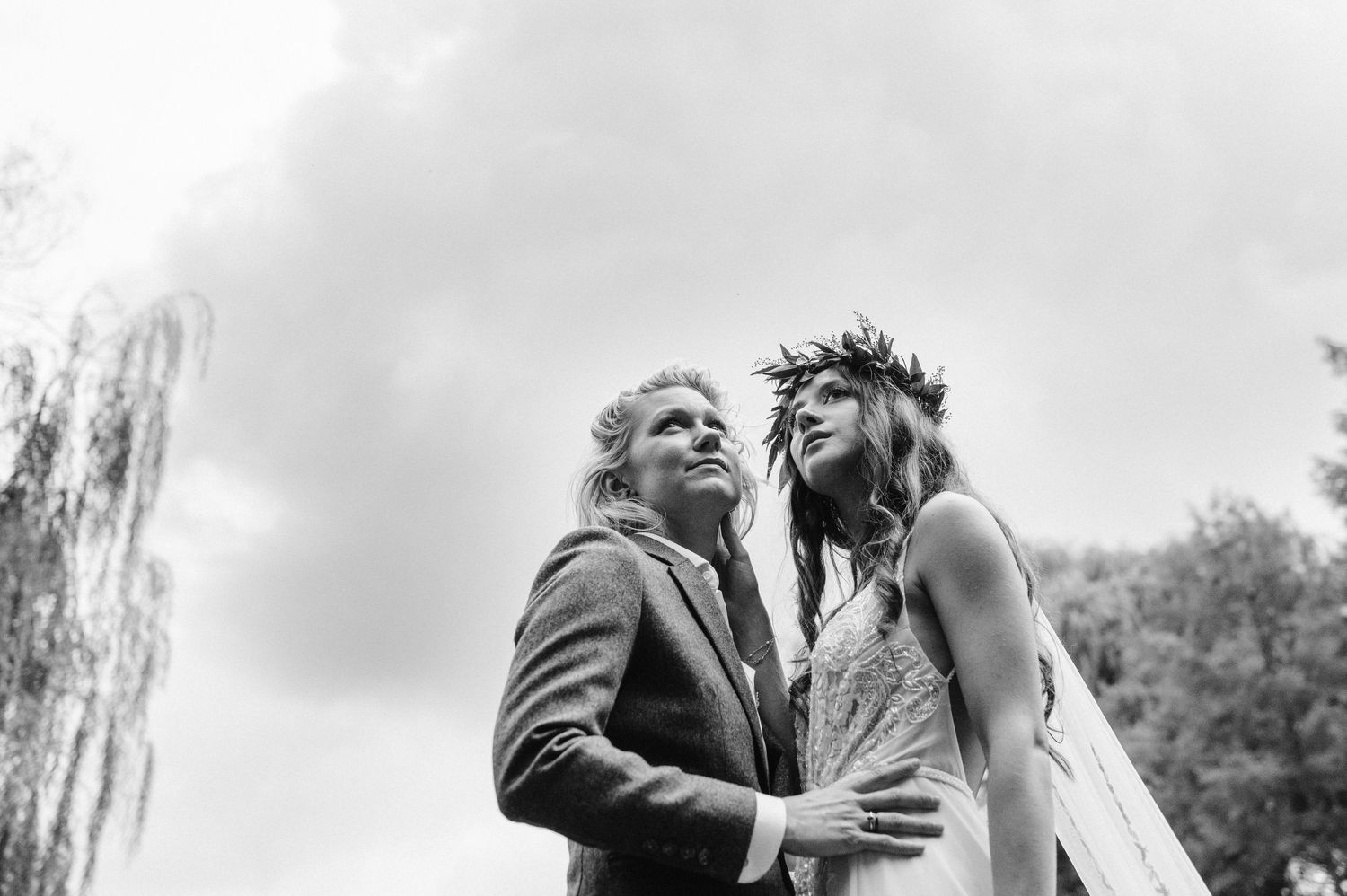 An intimate black and white wedding portrait capturing a tender moment outdoors.