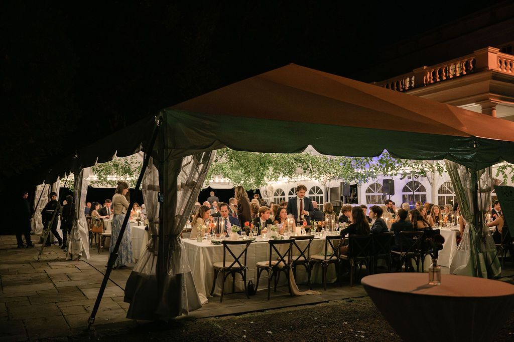 Outdoor evening wedding reception under string lights and tents creating a romantic ambiance at Strong Mansion on Sugarloaf Mountain