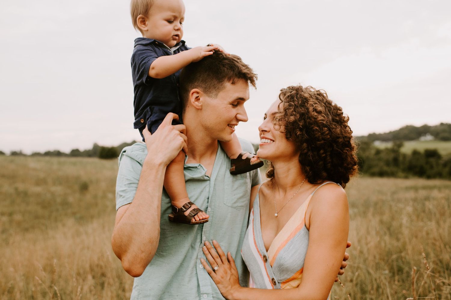 Candid family moment captured in black and white with joyful expressions in field setting.