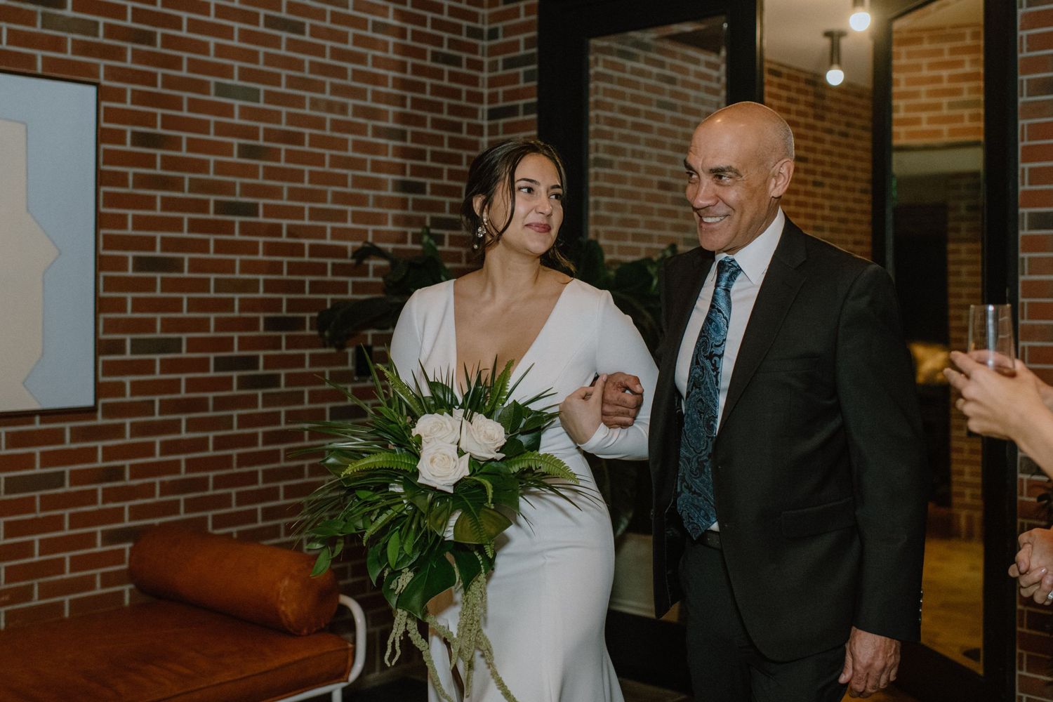 Formal event entrance with brick wall and decorative plants.