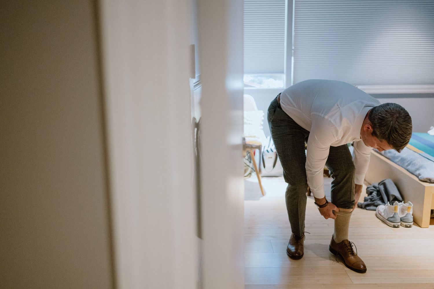 Someone bending down to adjust something in a bright minimalist room.