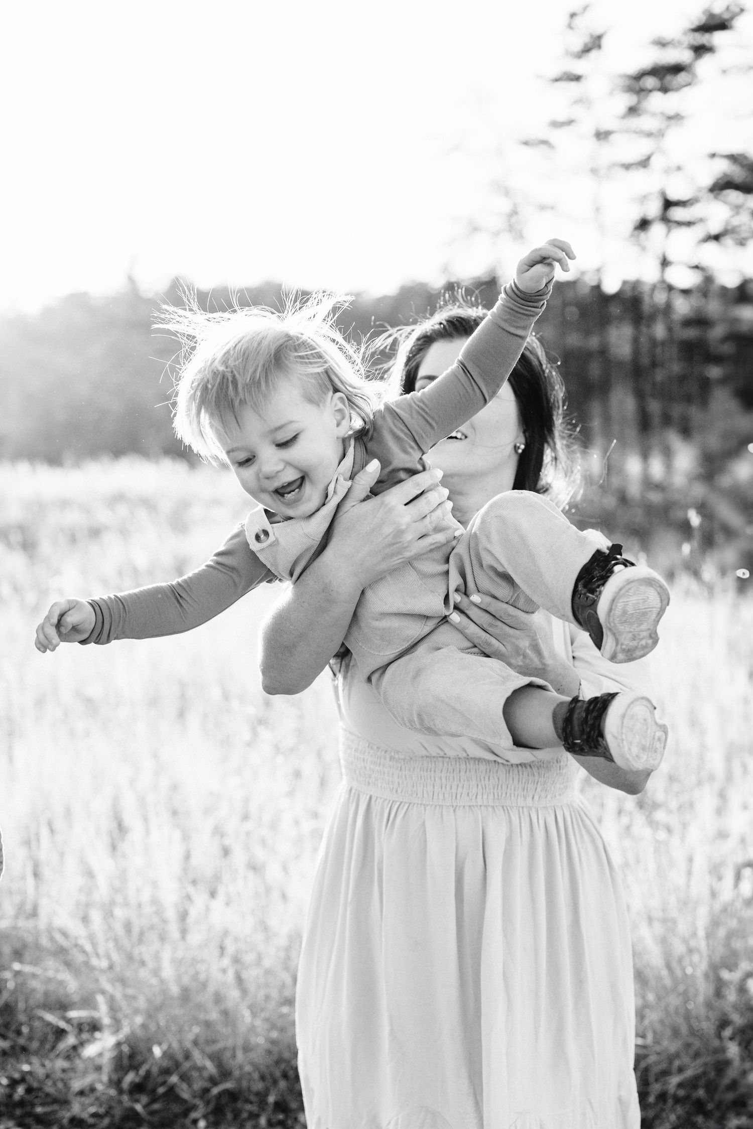 Black and white photo of joyful playtime in a sun-drenched field.