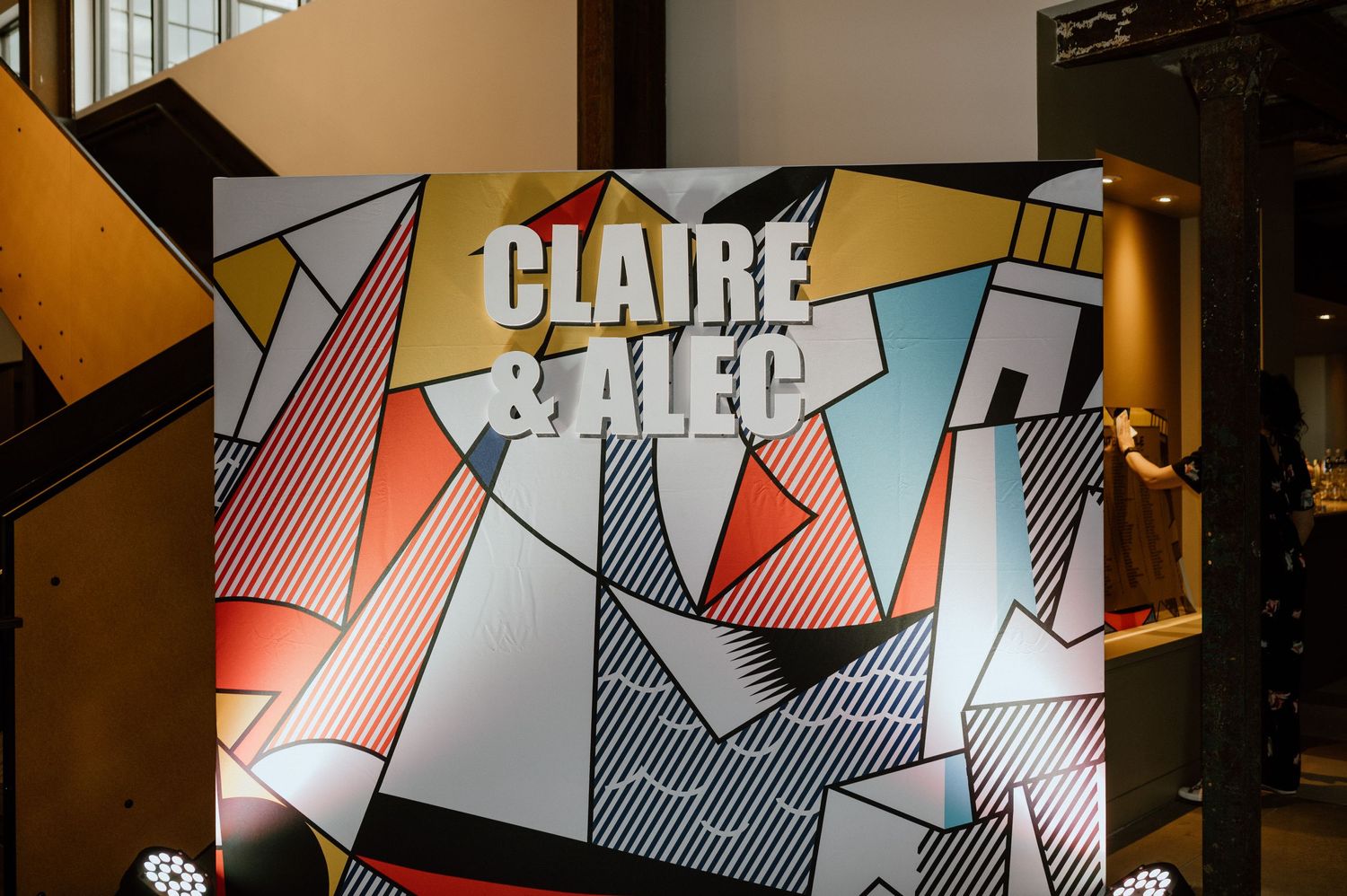 Modern geometric art installation with text displayed in orange and white angular design.