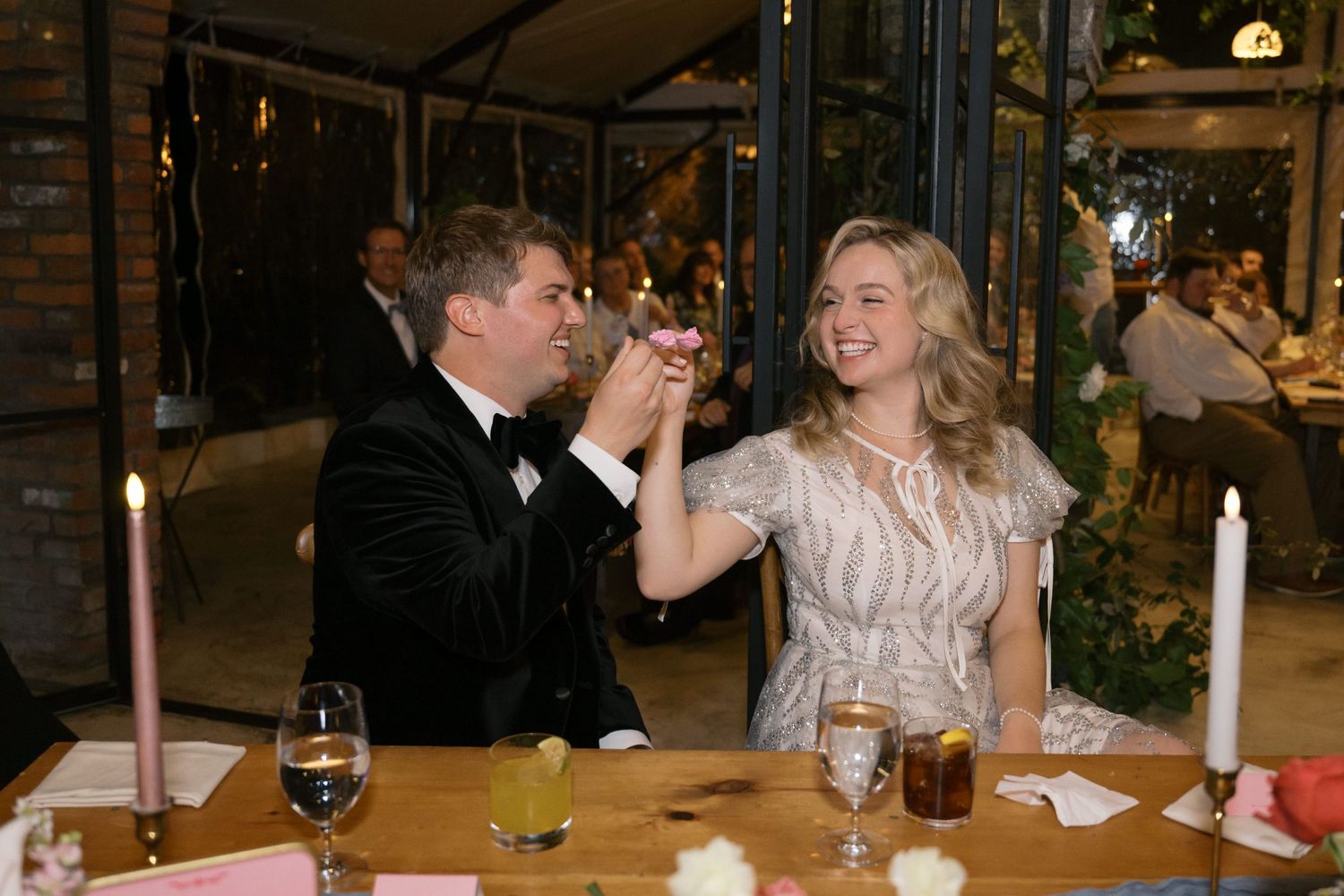 A couple shares a toast at their reception table.