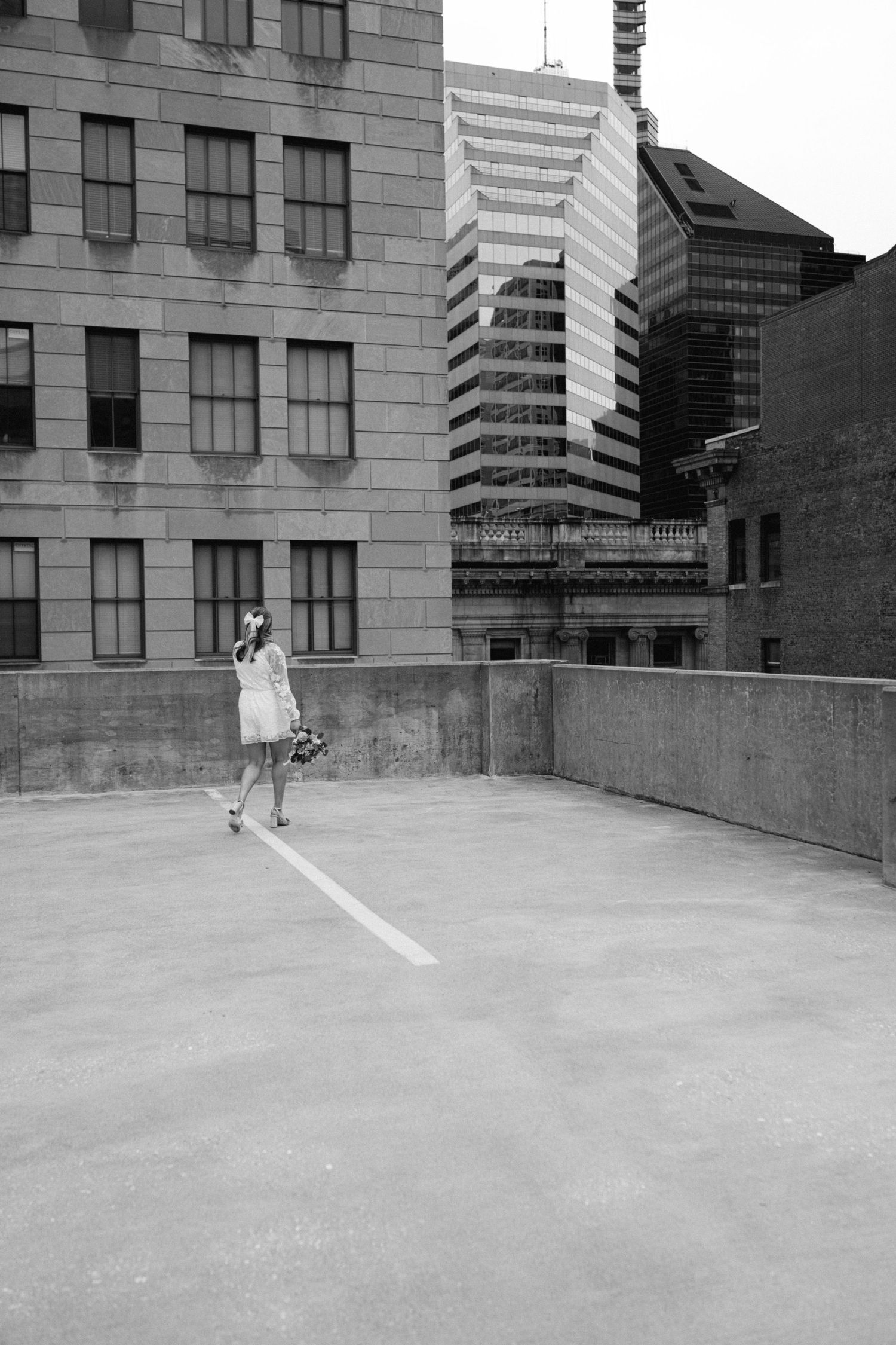 Black and white photo of a rooftop urban scene with city buildings in the background.