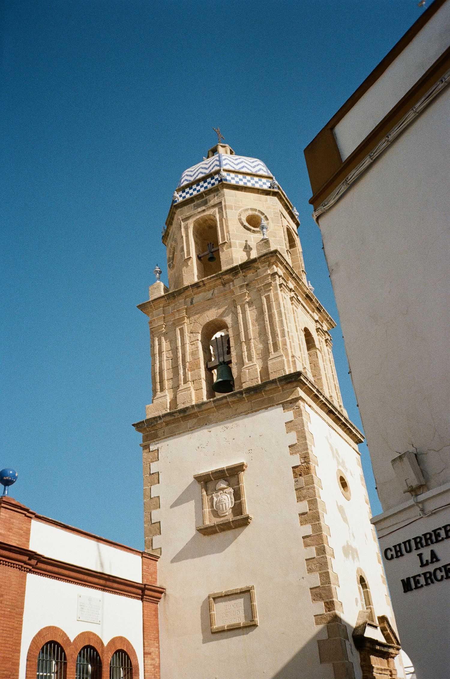 White church bell towers with stone trim against bright blue sky in Spanish architectural style.