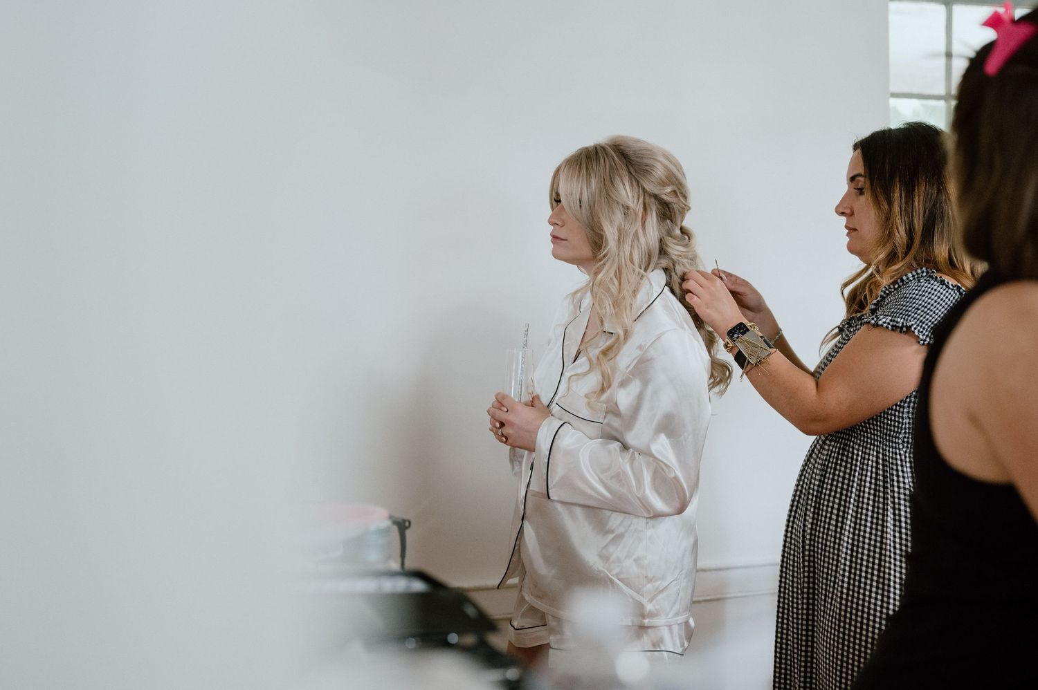 Getting ready scene with someone having their hair styled in a white robe.