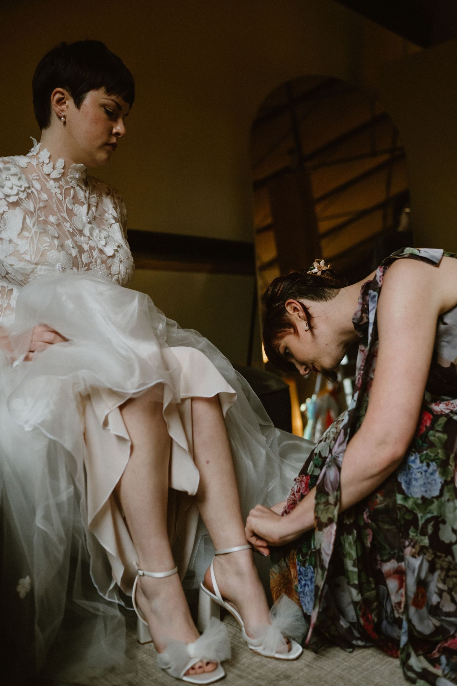 Close-up shot of wedding shoes being adjusted on bride's feet during preparation.