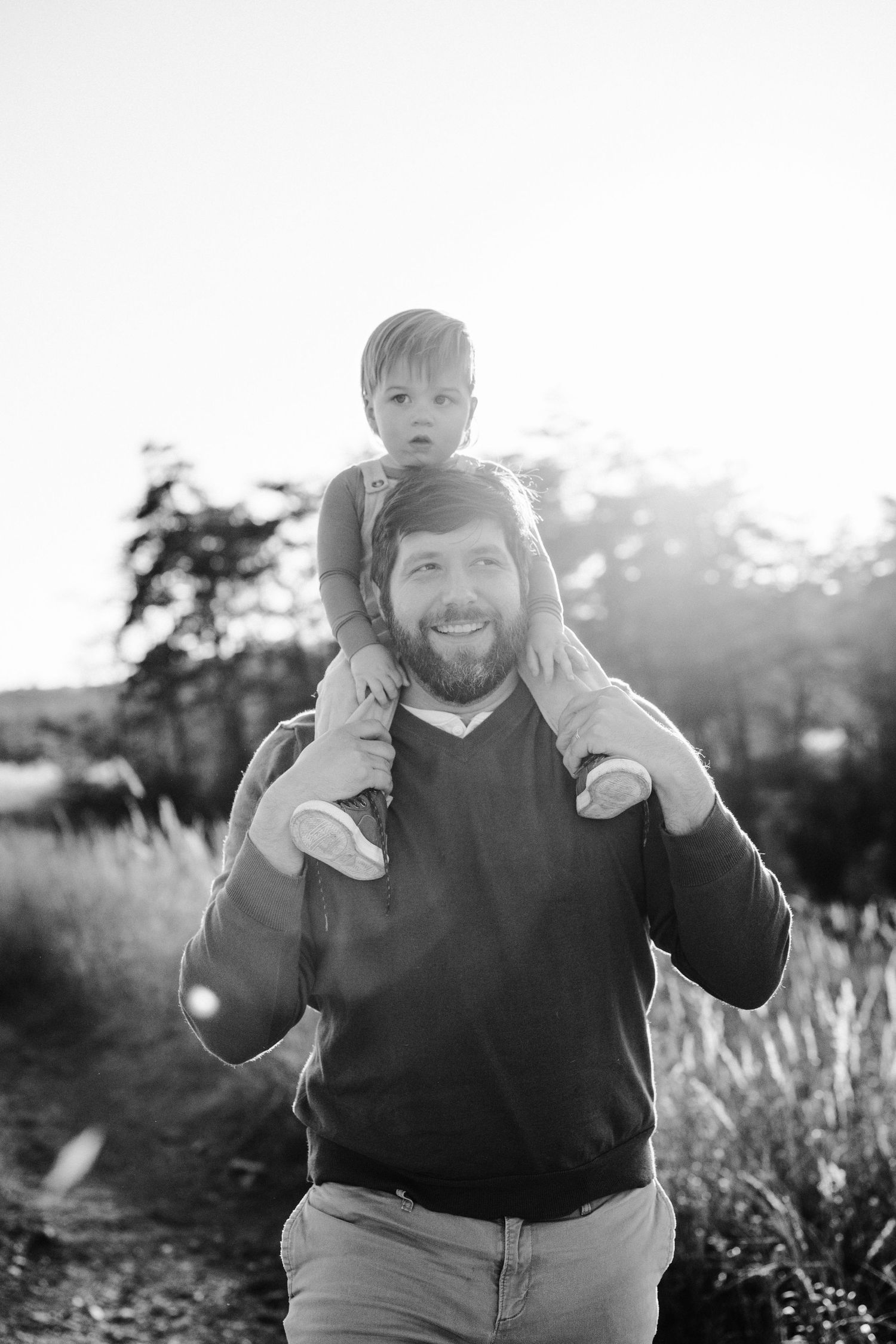 Black and white portrait of father and child in outdoor setting.