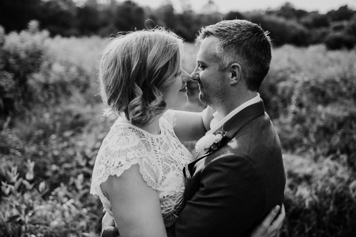 Black and white intimate portrait of couple sharing tender moment outdoors.