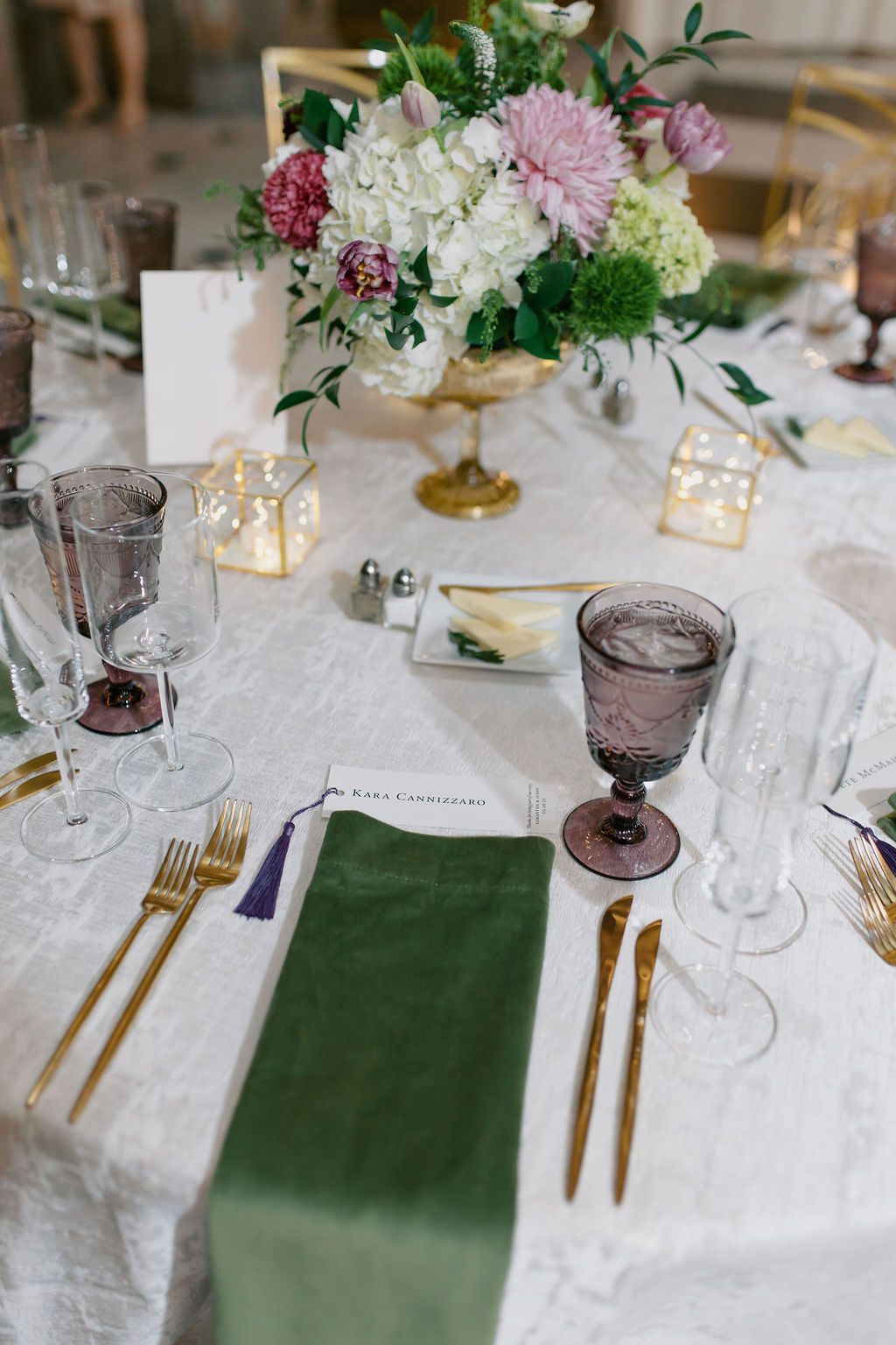 Wedding table setting with pink and white floral centerpiece, green runner, and gold cutlery at George Peabody Library Wedding in Baltimore